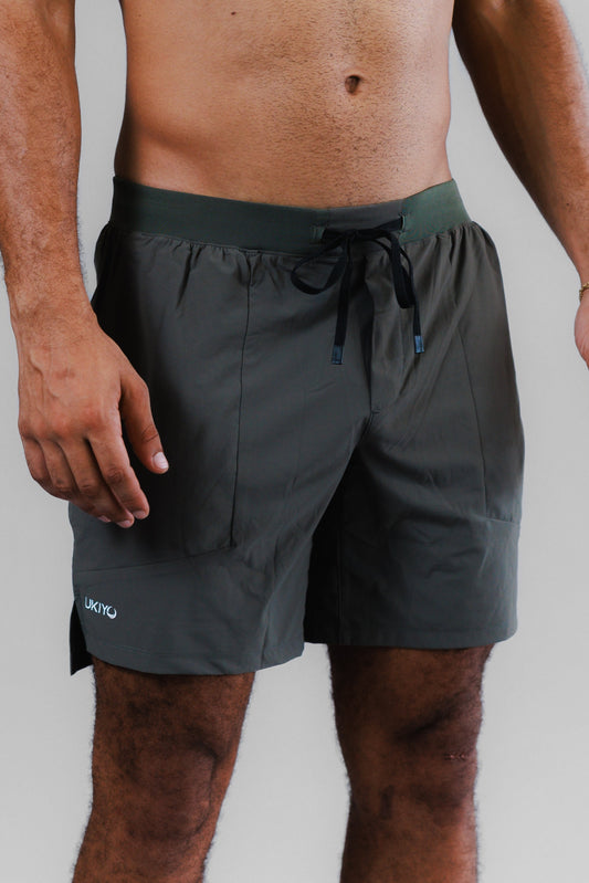 Person wearing light green shorts on a plain background